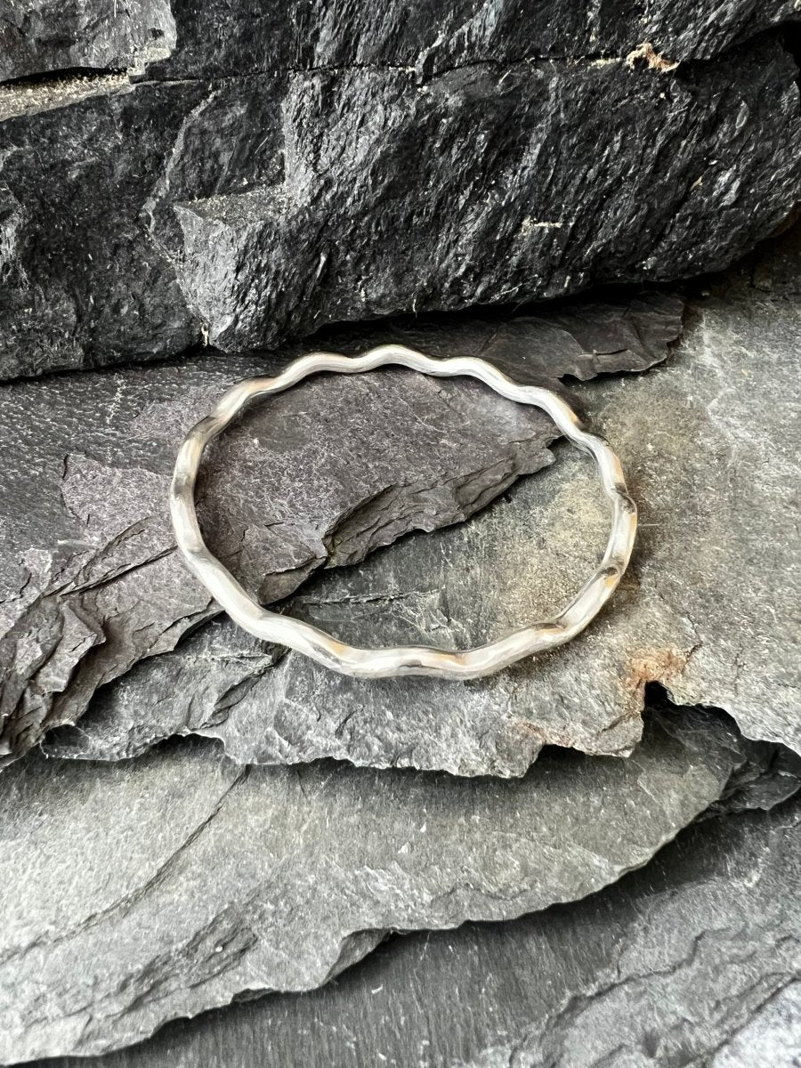Overhead View of Sterling Silver Textured Wave Bangle (3.5 mm) Sat on Slate Pieces