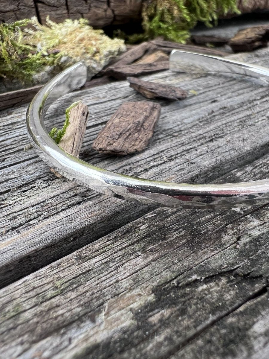 Close-up of a handmade sterling silver 3.5mm Aurora Crescent torque bangle showing the slim hammered band and open ends