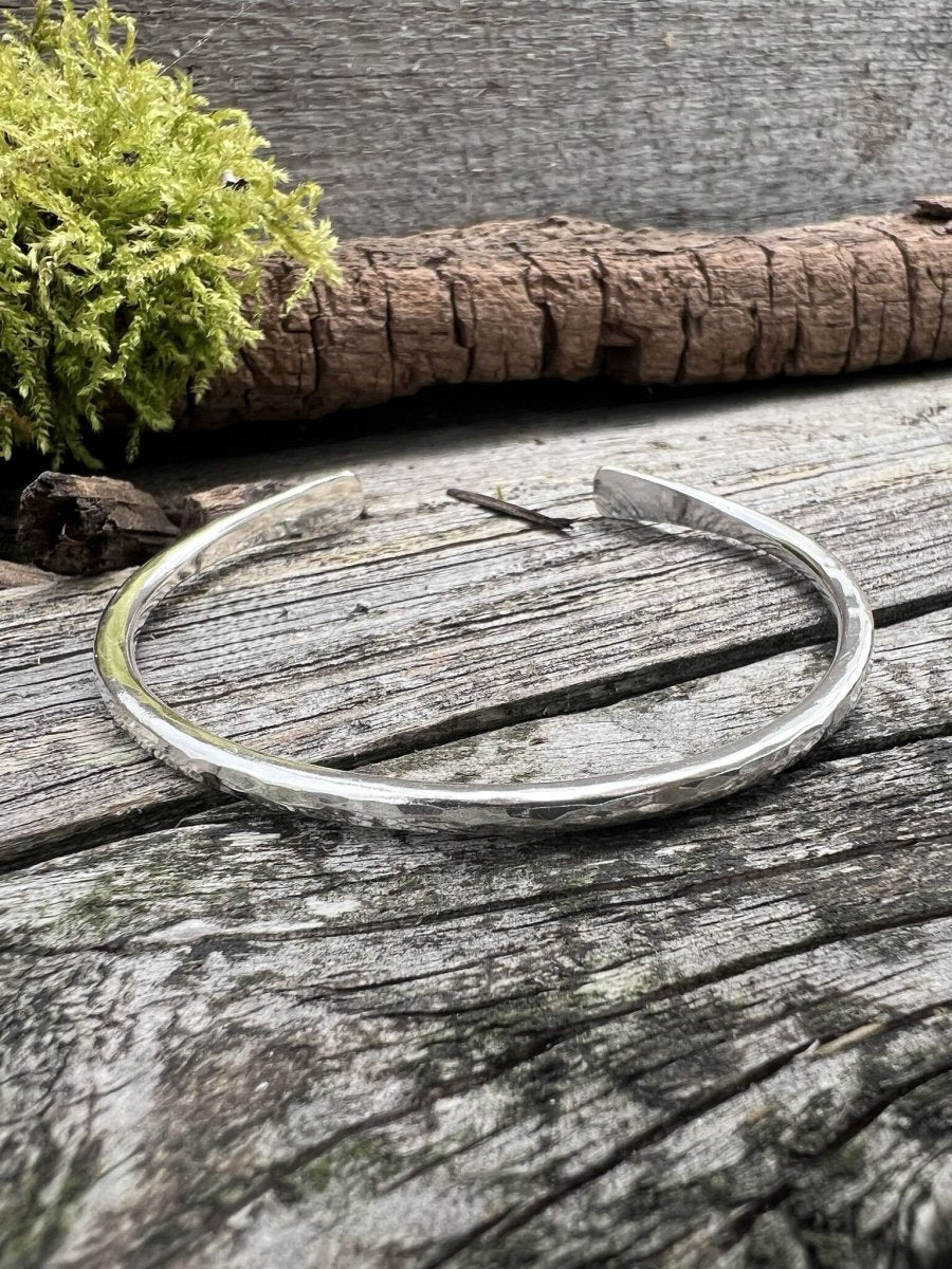 Recycled sterling silver Aurora Crescent torque bangle, 3.5mm, on weathered wood with moss and bark