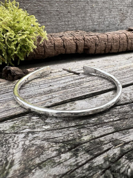 Recycled sterling silver Aurora Crescent torque bangle, 3.5mm, on weathered wood with moss and bark