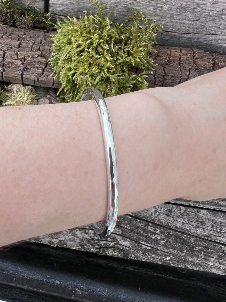 Recycled sterling silver 3.5mm Aurora Crescent torque bangle worn on a wrist, showing the slimmer band scale