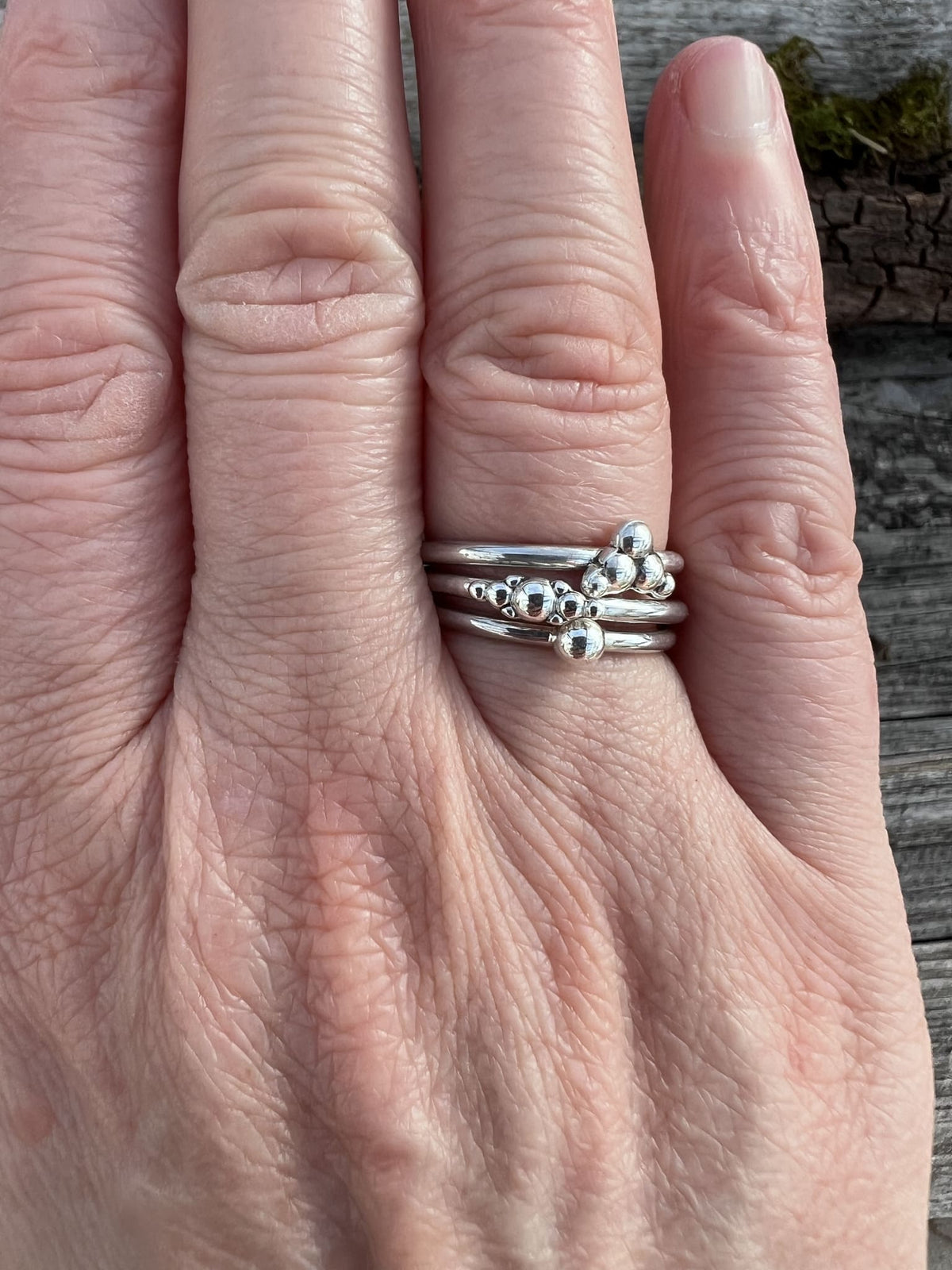 Recycled sterling silver granule rings worn stacked on a finger, showing how they can be layered