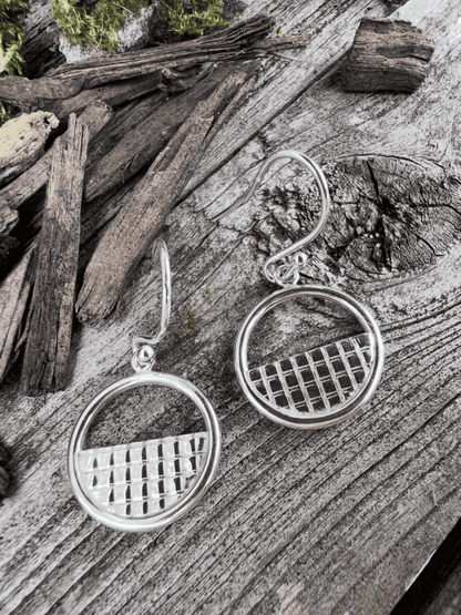 Recycled sterling silver lattice halo drop earrings on weathered wood, showing the halo frame with woven lattice centre