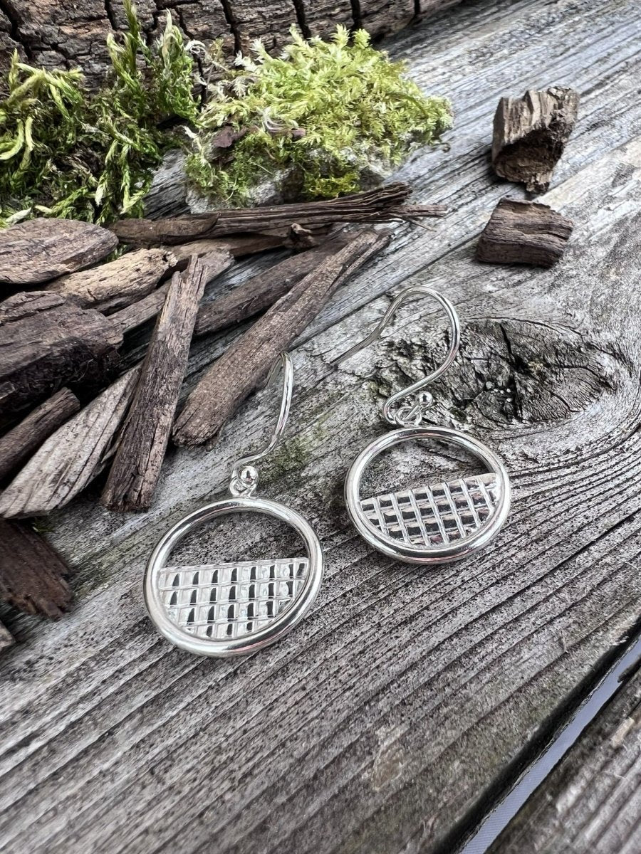 Recycled silver lattice halo drop earrings styled on weathered wood with moss and wood chips, showing both earrings and the detailed lattice work