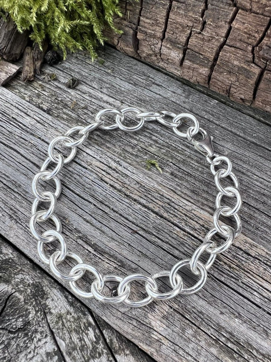Recycled sterling silver Lina trace bracelet on weathered wood, showing the large oval chain links