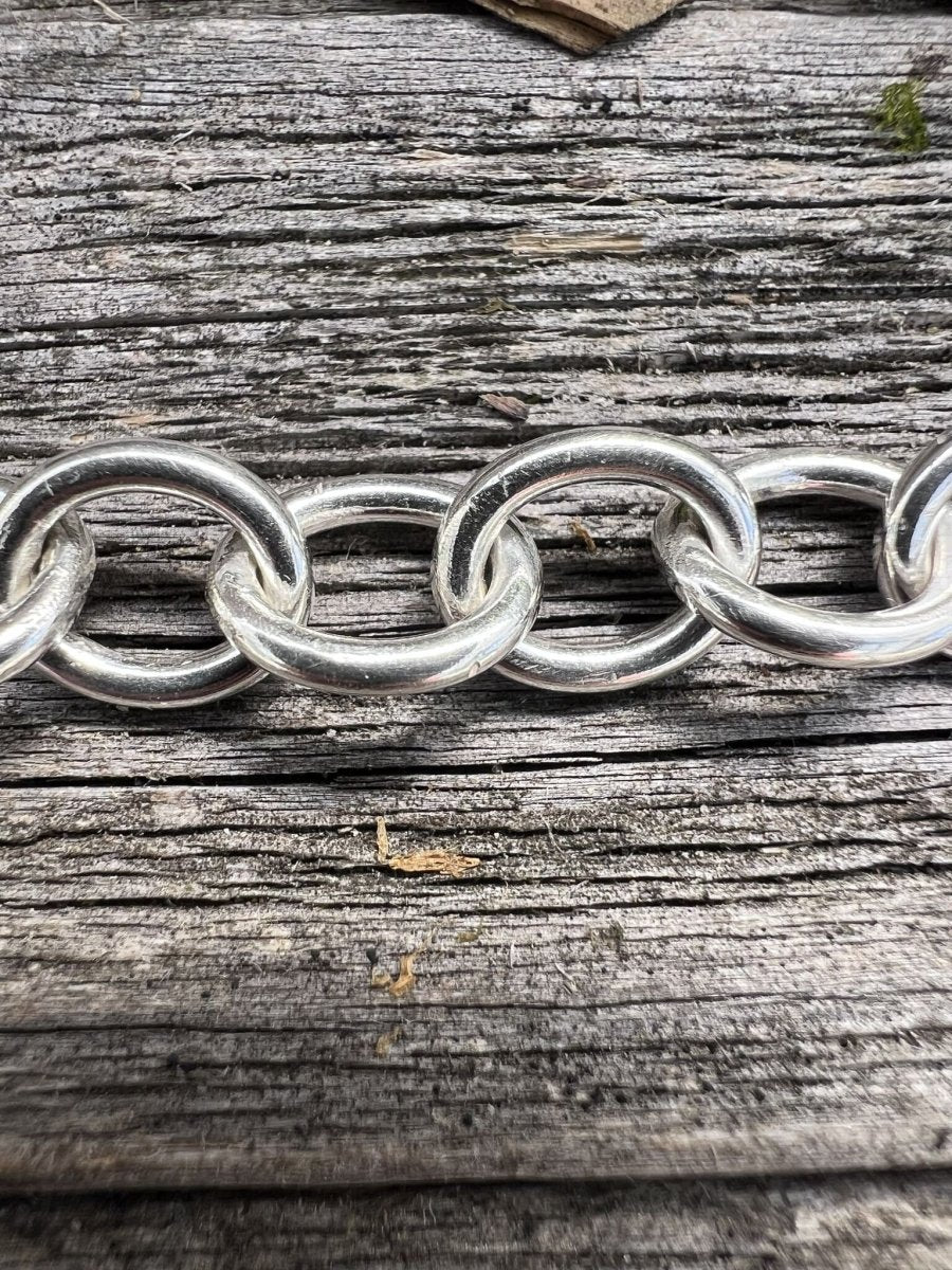 Recycled sterling silver Lina trace bracelet on weathered wood, showing the oval chain links laid flat
