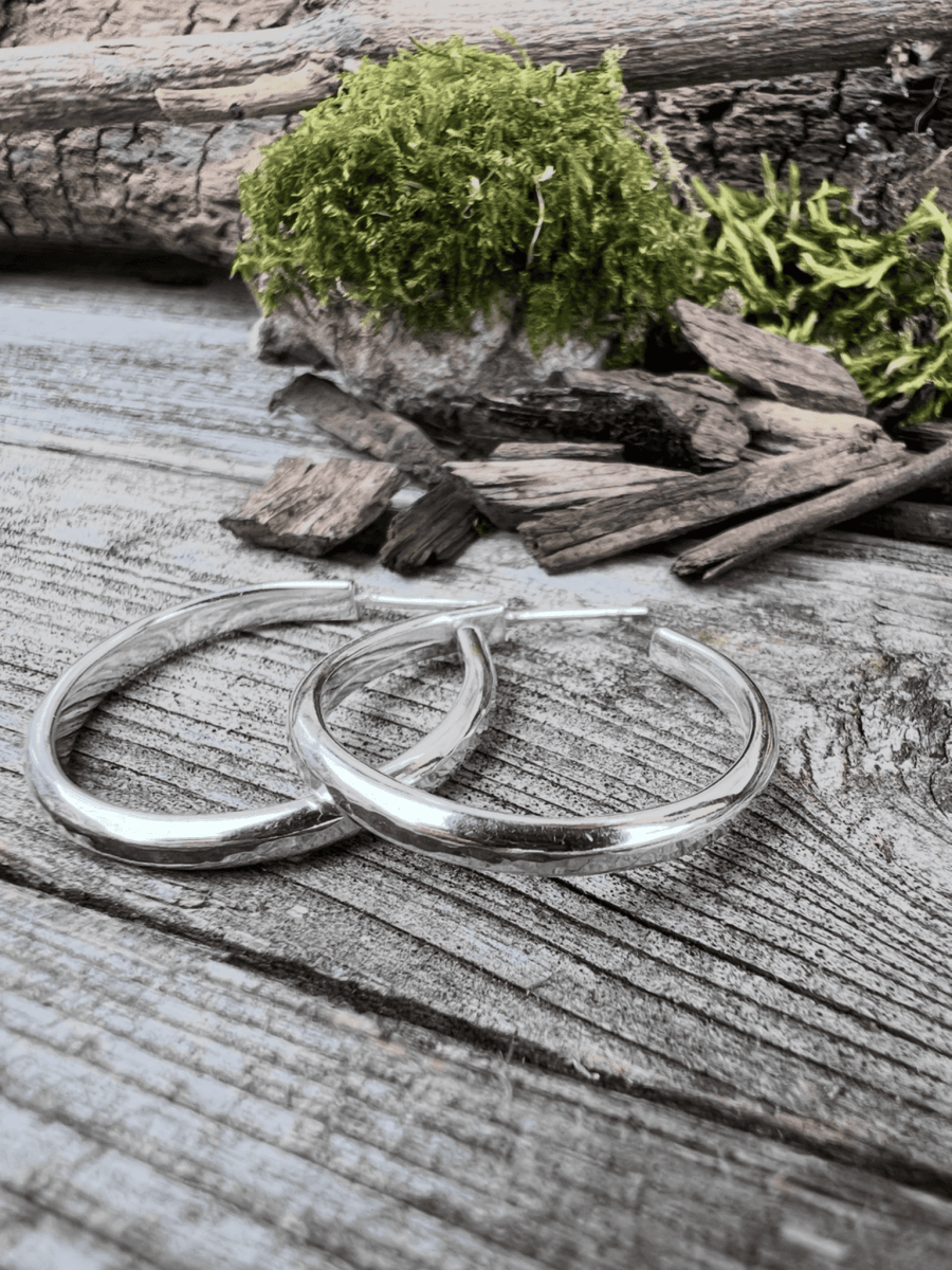 Recycled sterling silver mini luxe hoop medium earrings lying flat on weathered wood