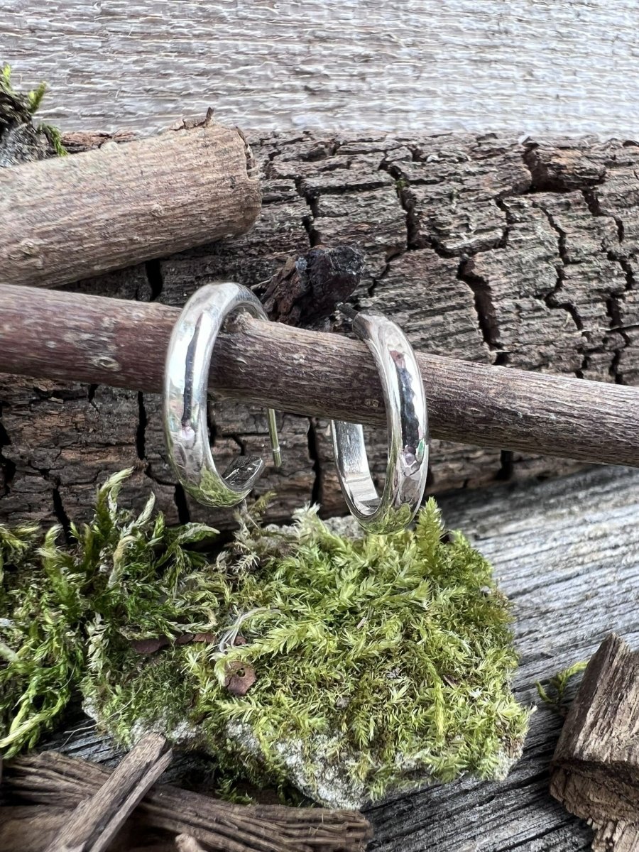 Recycled silver mini luxe hoop small earrings hanging from a branch with moss and wood chips in background