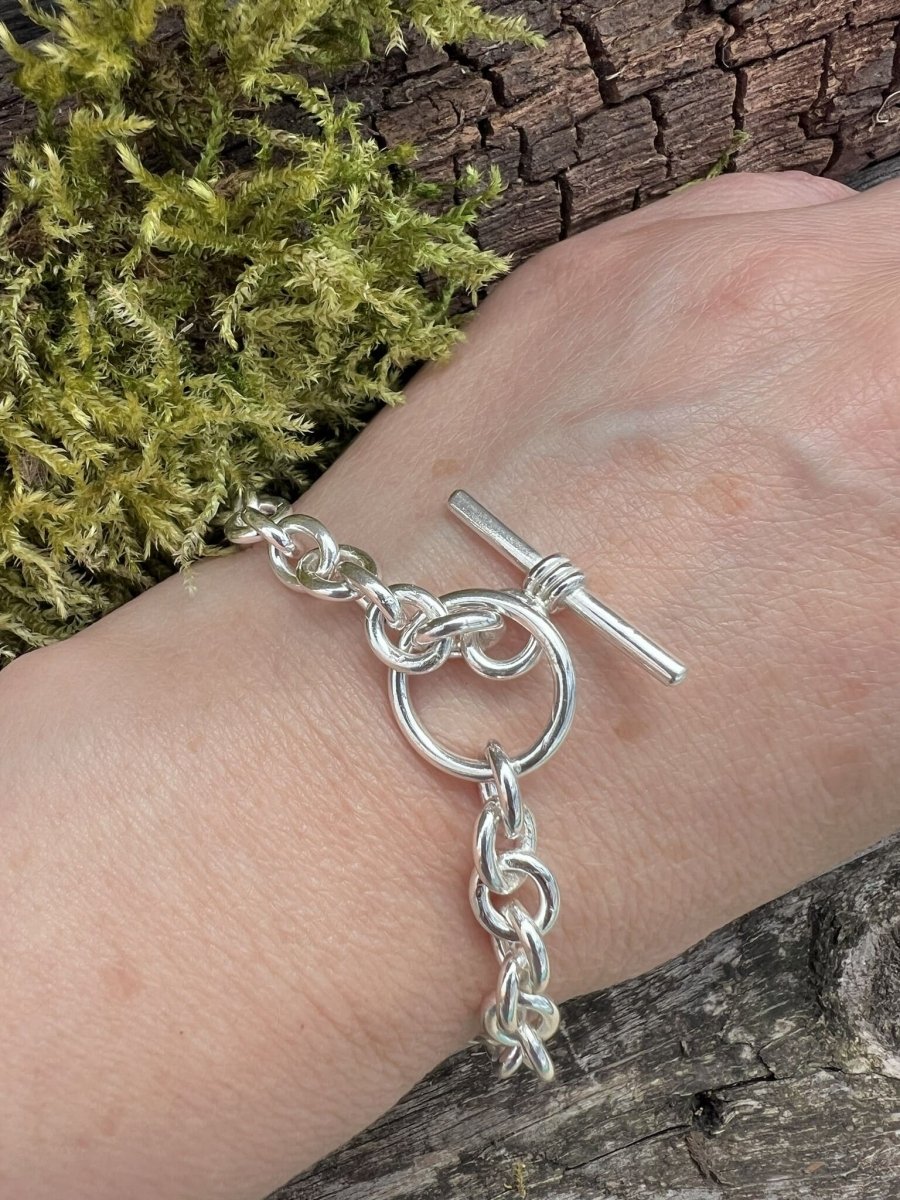 Recycled sterling silver Nova oval loop bracelet worn on a wrist, showing the chunky oval links and toggle clasp detail