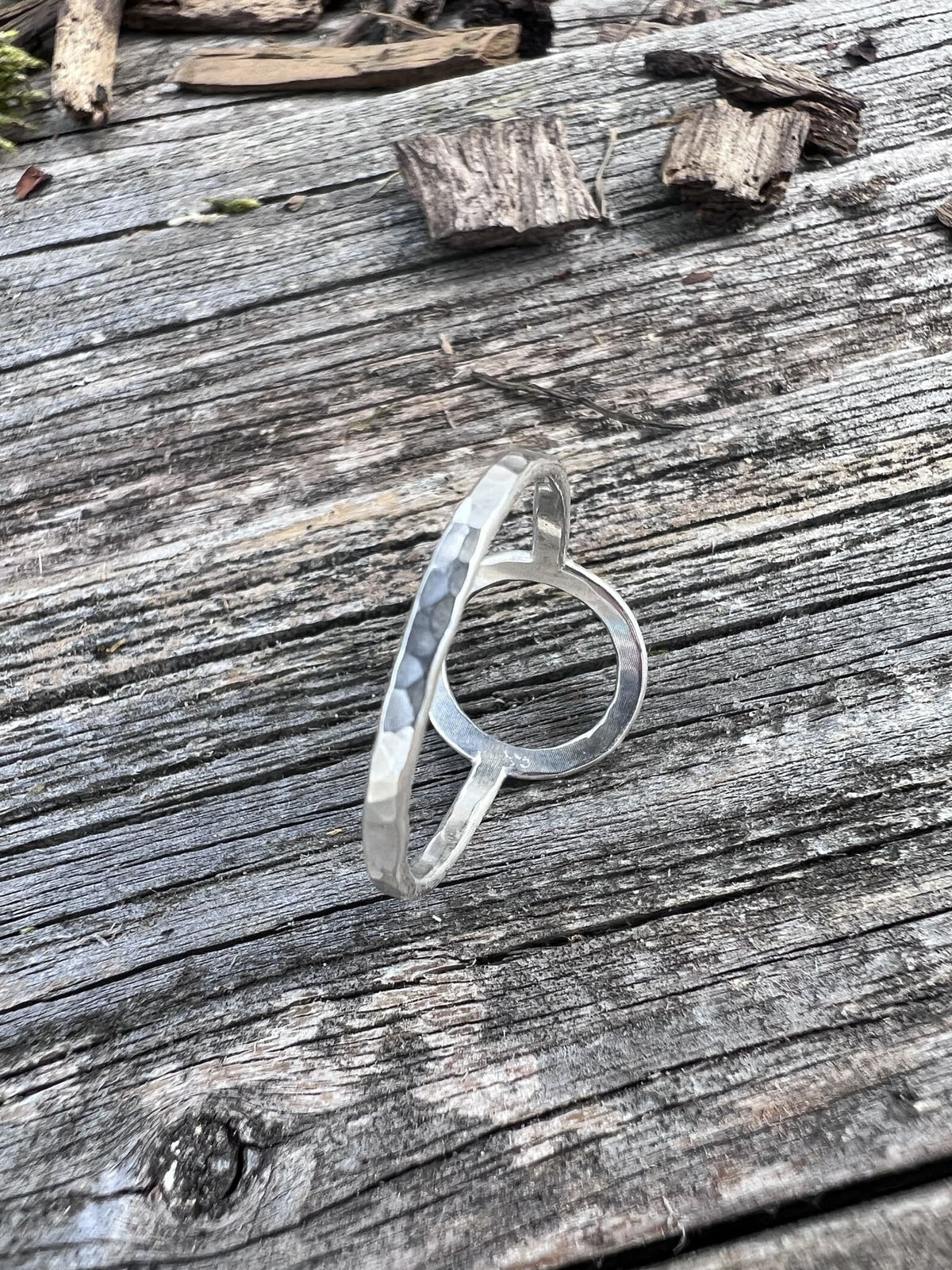 Recycled sterling silver open circle ring on weathered driftwood, handmade Isle of Wight jewellery