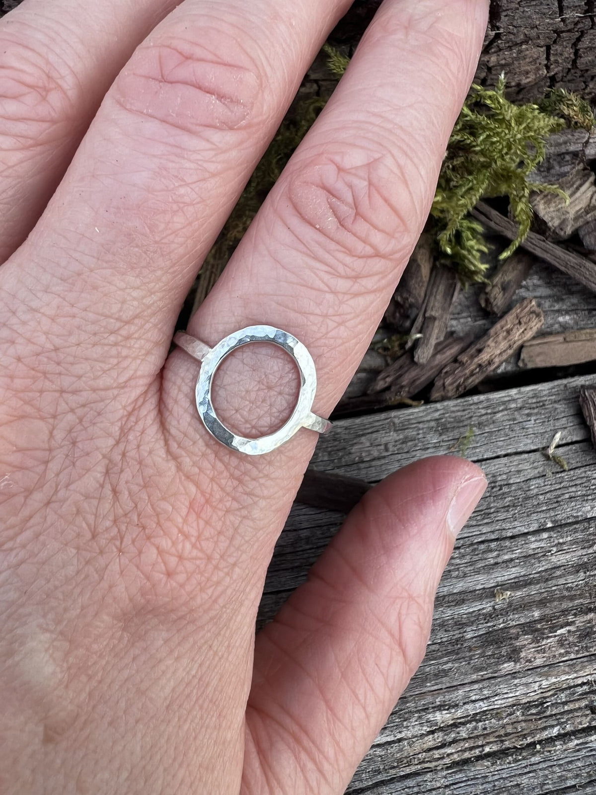 Sterling silver open circle ring worn on a finger, showing scale and the clean oval frame design