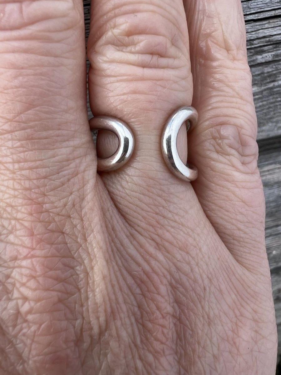 Sterling silver open end loop ring worn on a finger, showing scale and fit against a neutral background
