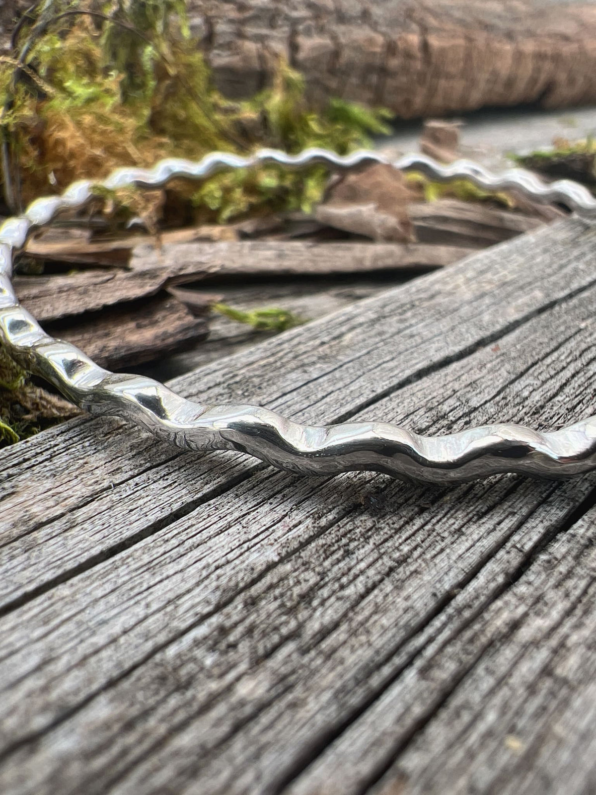 Close-up of a handmade sterling silver ripple wave bangle 2.5mm, showing the rippled corrugated edge texture