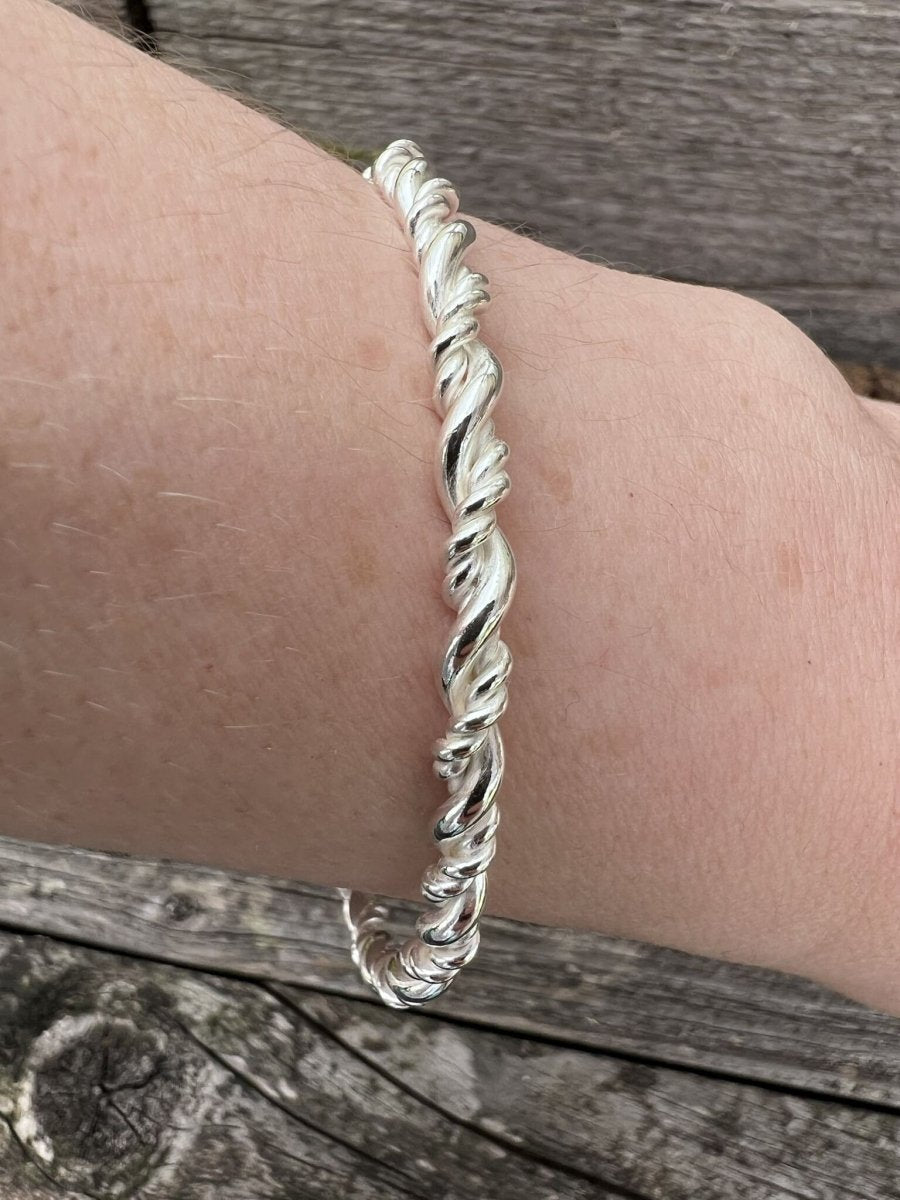 Recycled sterling silver rope twist bangle worn on a wrist, showing scale and the twisted band detail