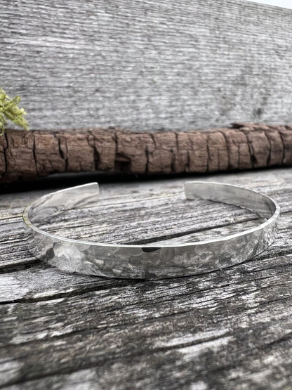 Recycled sterling silver Sierra textured torque bangle on weathered wood, showing the heavily textured open band