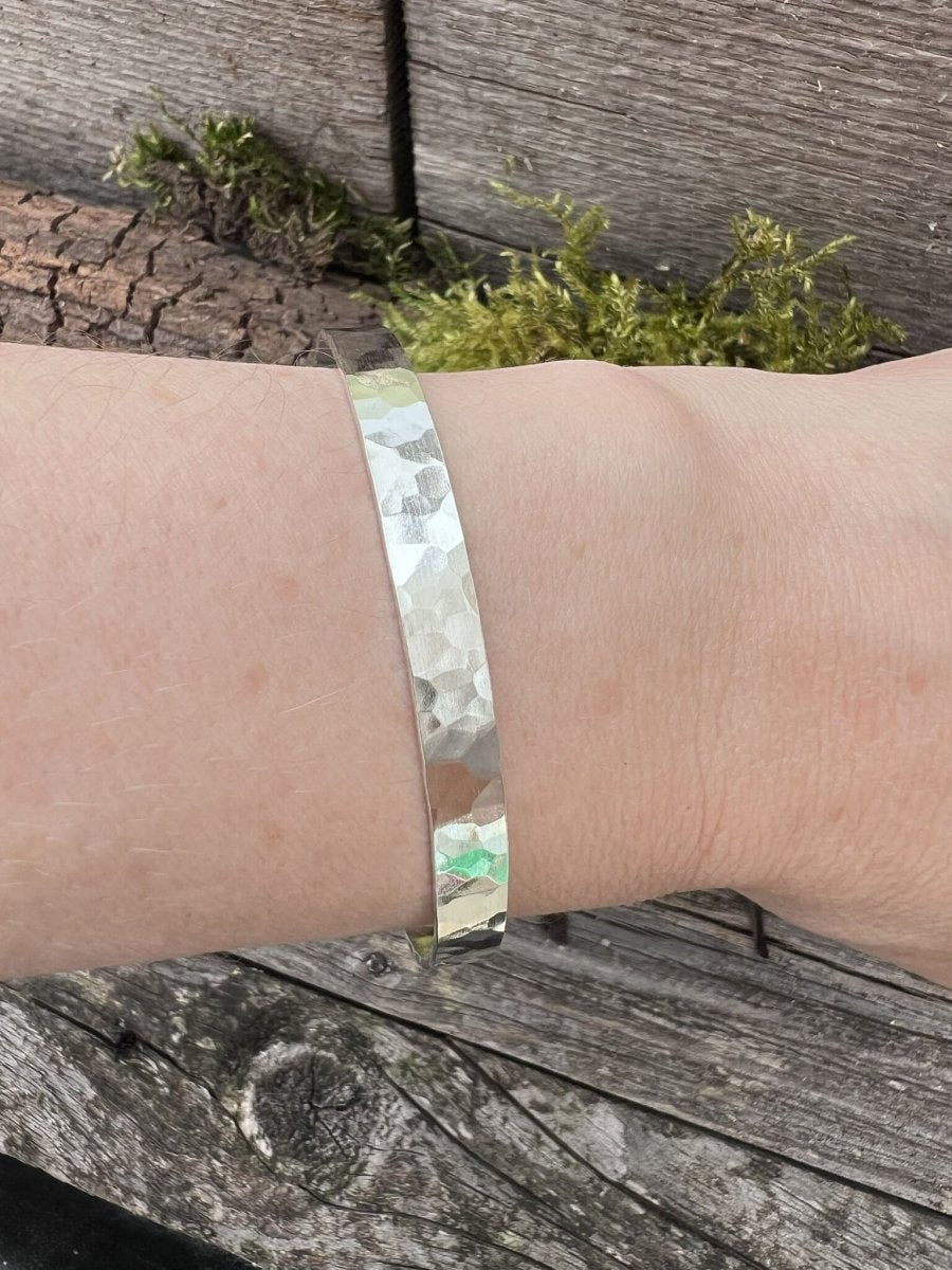 Recycled sterling silver Sierra textured torque bangle worn on a wrist, showing the textured band