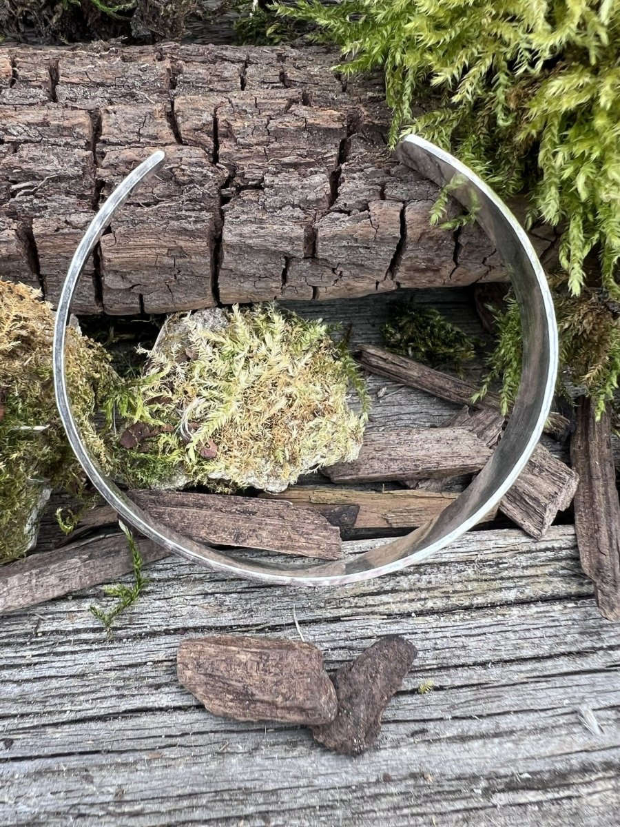 Recycled sterling silver Sierra textured torque bangle styled open on weathered wood with moss and bark pieces