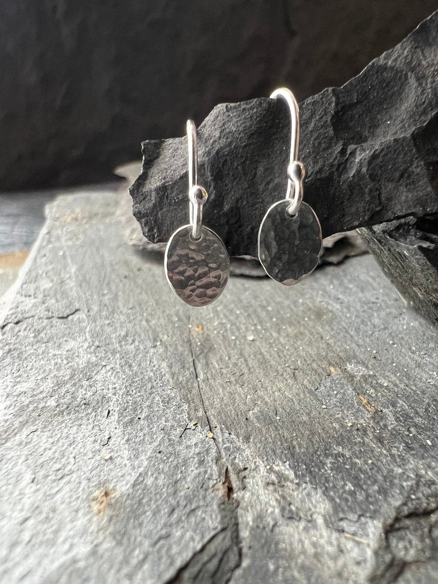 Sterling Silver Petite Textured Oval Earrings Hanging from Charcoal Piece - Kerry Gallop Jewellery