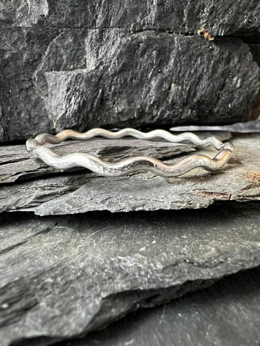 Close Up of Sterling Silver Textured Wave Bangle (3.5 mm) Sat on Slates