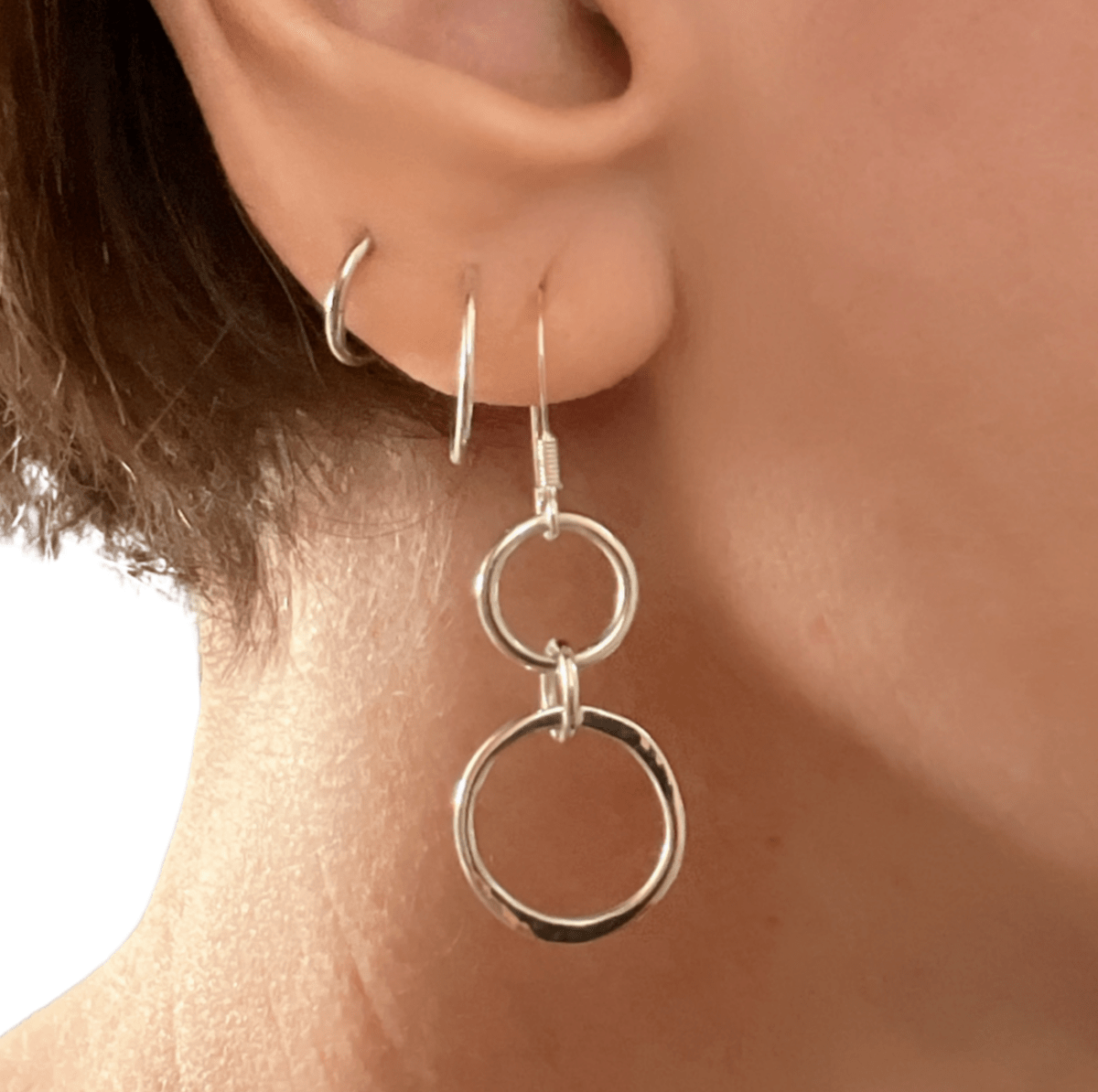 Sterling silver unity drop earrings worn in ear, showing how the linked double circle design sits and moves