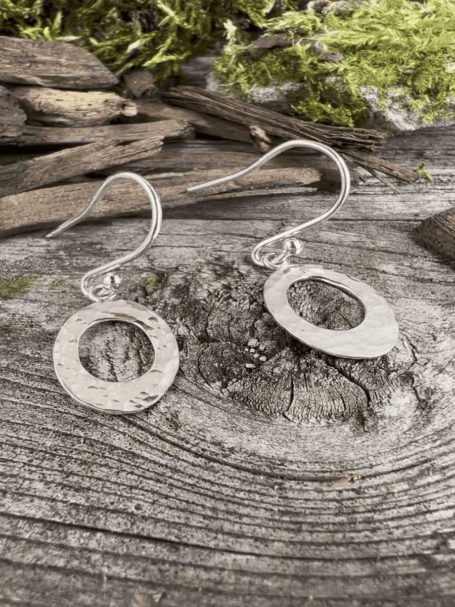 Recycled silver textured oval drop earrings styled on weathered wood, showing both earrings together with natural textures