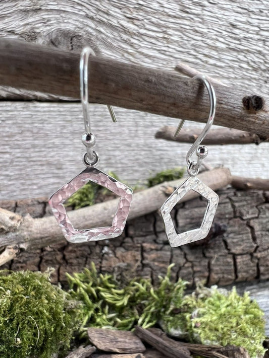 Recycled sterling silver textured pentagon drop earrings hanging from a branch with moss, showing the open five-sided geometric pendant