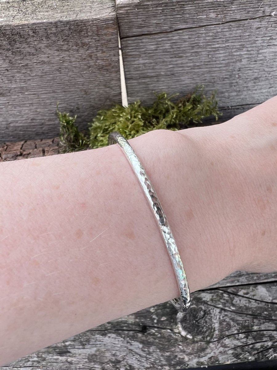 Recycled sterling silver 3.5mm textured round bangle worn on a wrist, showing the band scale and fit