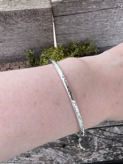 Recycled sterling silver 3.5mm textured round bangle worn on a wrist, showing the band scale and fit