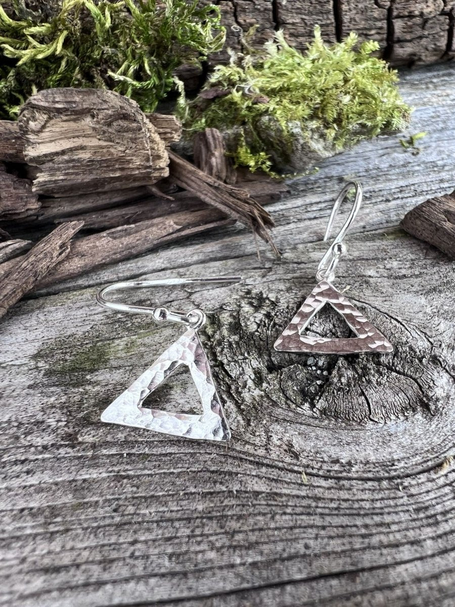 Recycled sterling silver textured triangle drop earrings on weathered wood, showing the open geometric triangle pendant