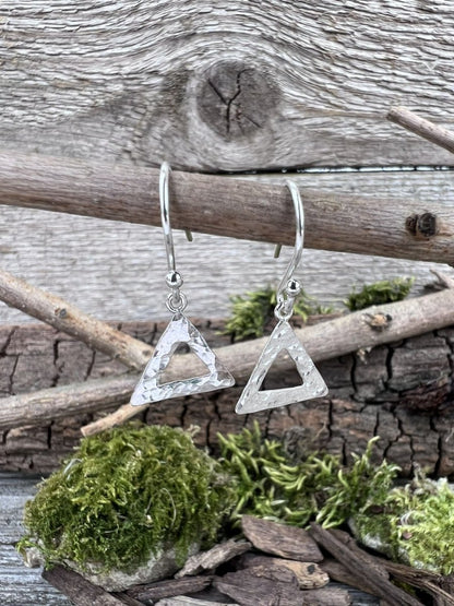 Recycled silver textured triangle drop earrings hanging from wooden branch with moss, showing the geometric design