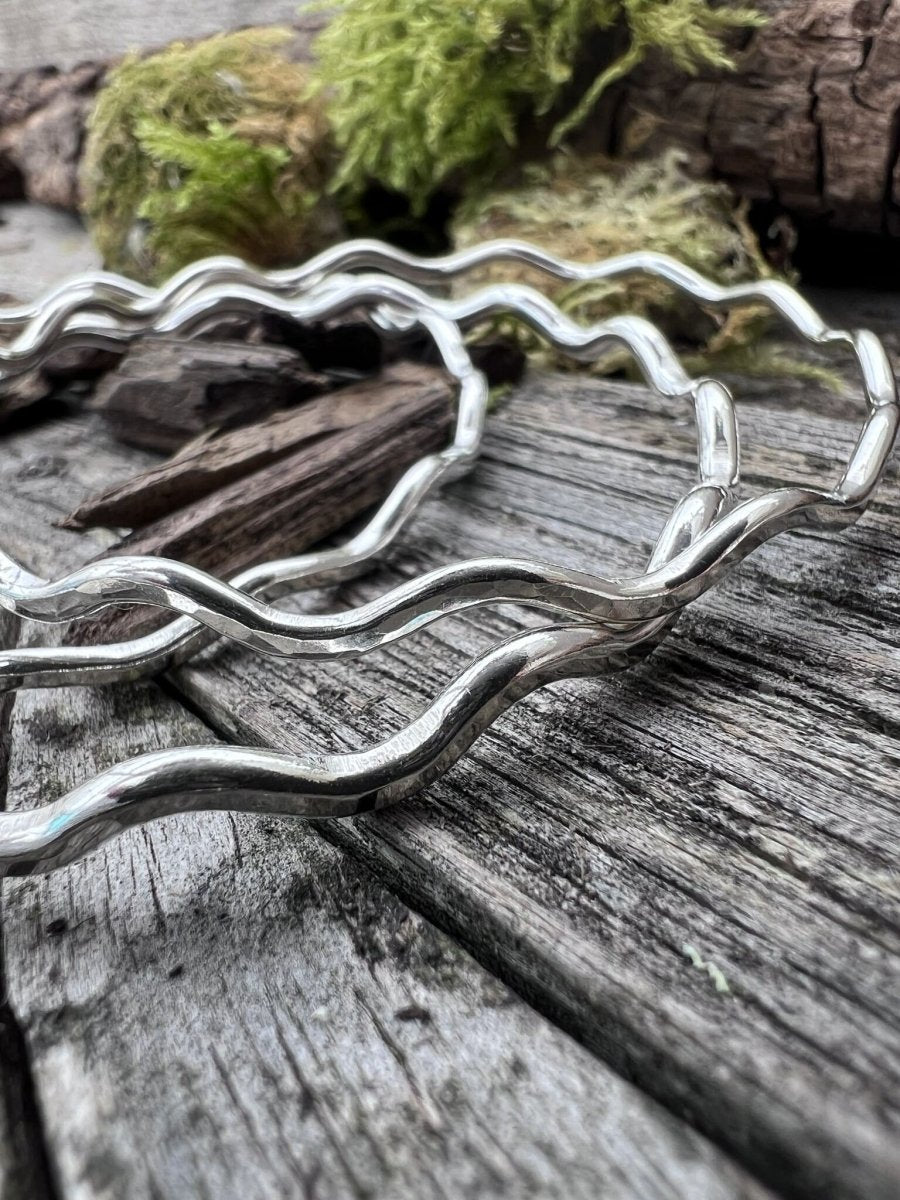 Recycled sterling silver 2.5mm wave bangles on weathered wood, handmade Isle of Wight jewellery
