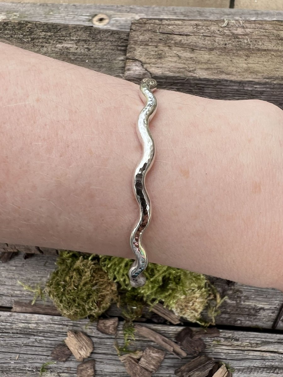 Recycled sterling silver 3.5mm wave bangle worn on a wrist, showing the flowing wave band and fit