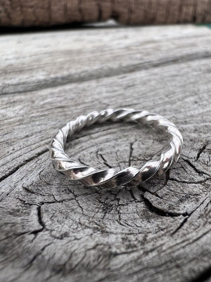 Thin sterling silver square twist ring on weathered wood