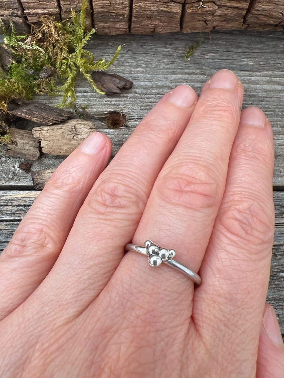 Sterling silver triple granule ring worn on finger, showing scale and the delicate cluster of three silver beads