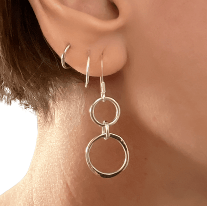 Sterling silver unity drop earrings worn in ear, showing how the linked double circle pendant sits and moves