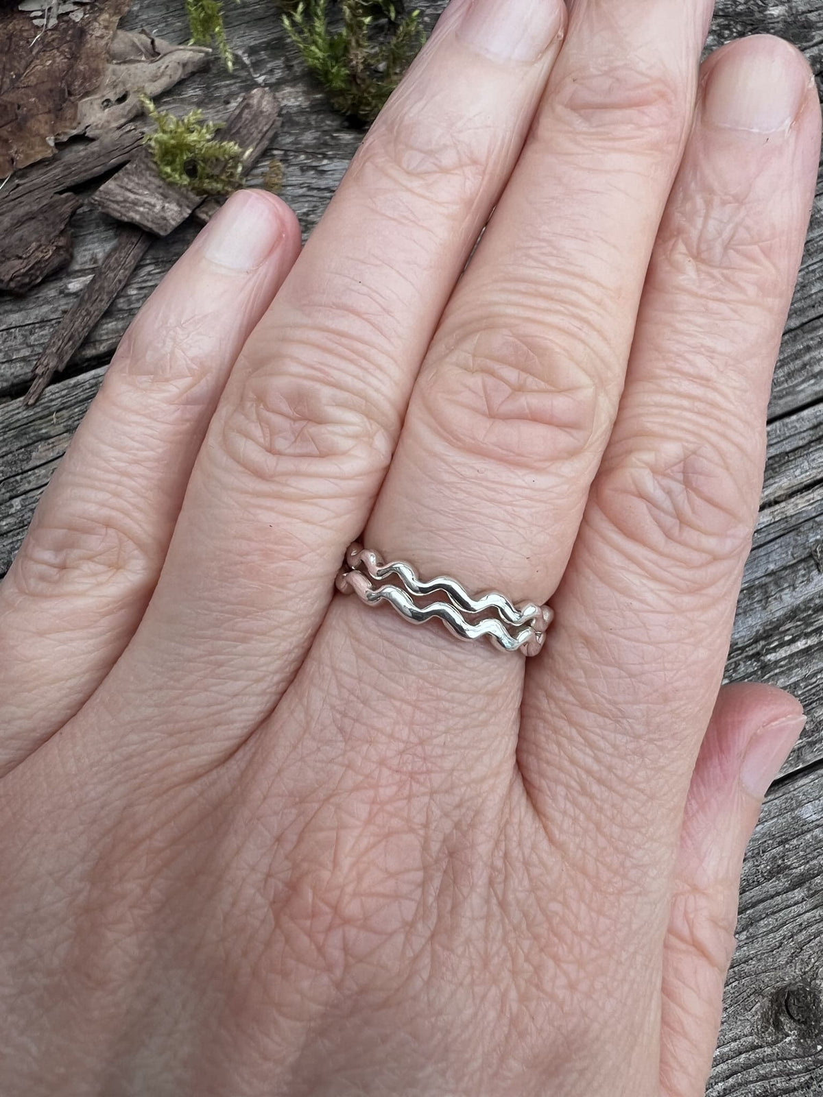 Recycled sterling silver wave rings stacked on finger, showing how the wave bands look when stacked